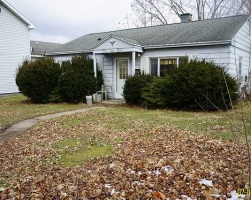 Old unkept front yard of house.